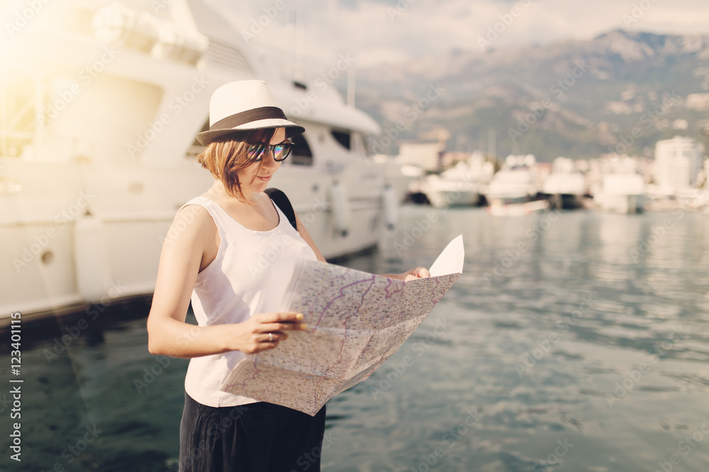 Woman with map near luxury ships at sea harbor