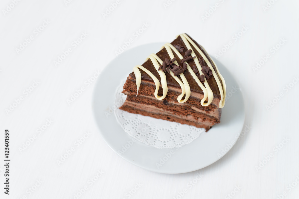 Fototapeta premium Delicious chocolate cake in white plate with cream isolated on light background