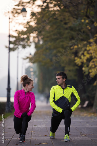 couple warming up before jogging