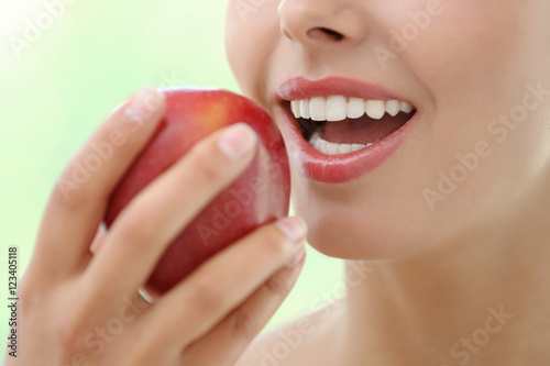 Young woman eating red appl...