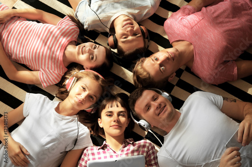 Happy friends lying and lis...