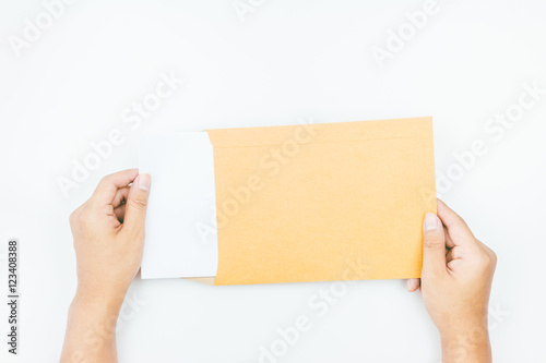Hands holding brown leather envelope with a empty paper on white © Art_Photo