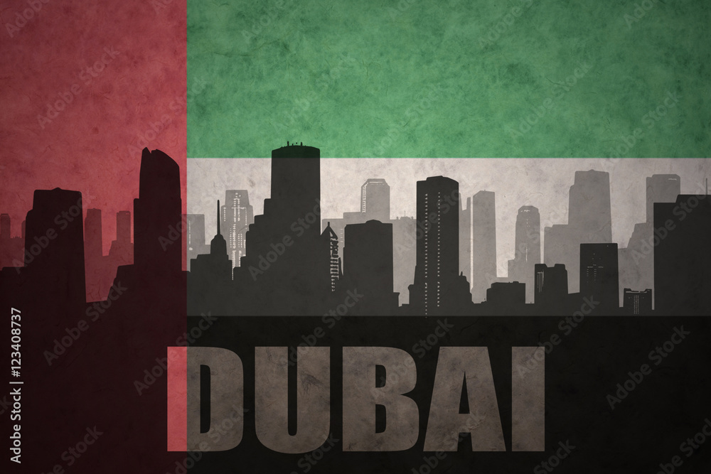 abstract silhouette of the city with text Dubai at the vintage united arab emirates flag background
