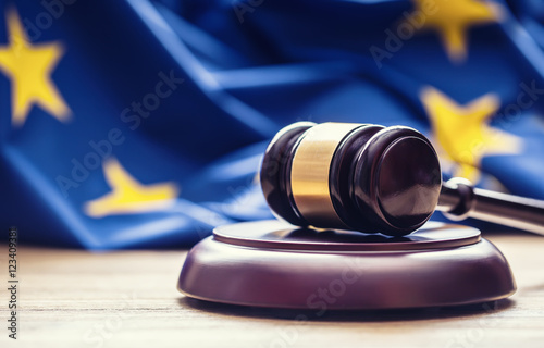 Judges wooden gavel with EU flag in the background. Symbol for jurisdiction. photo