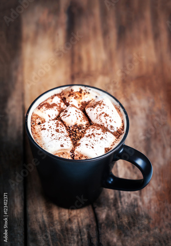 Hot chocolate with marshmallows on vintage wooden table close up