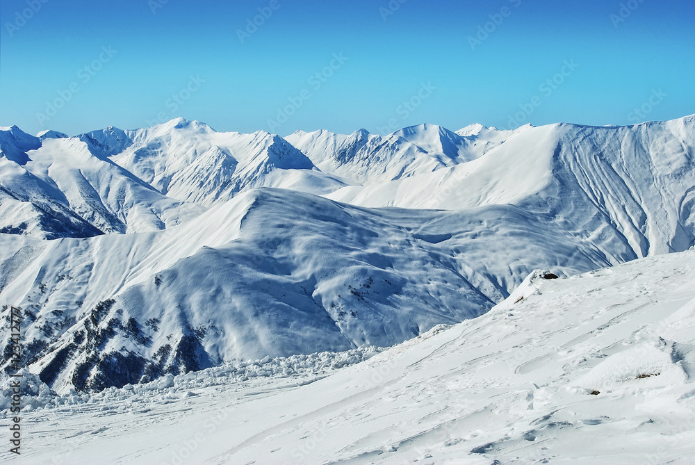 Snow white mountains at the day with clear blue sky. Caucasus. Winter landscape. Mountain climbing. Winter sport and recreation