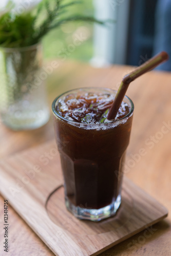 Obraz na płótnie Iced Americano black coffee on a wooden table. shallow depth of w salonie