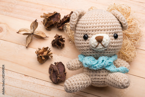 Knitted teddy bear on wood background