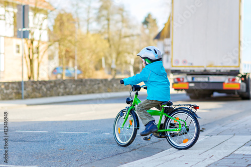 Little preschool kid boy biking on bicycle
