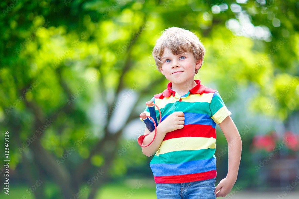 little kid boy shooting wooden slingshot little kid boy shooting wooden slingshot