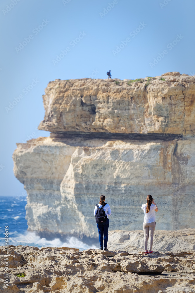 Couple on the cliffs of Azur Window, Gozo, Malta