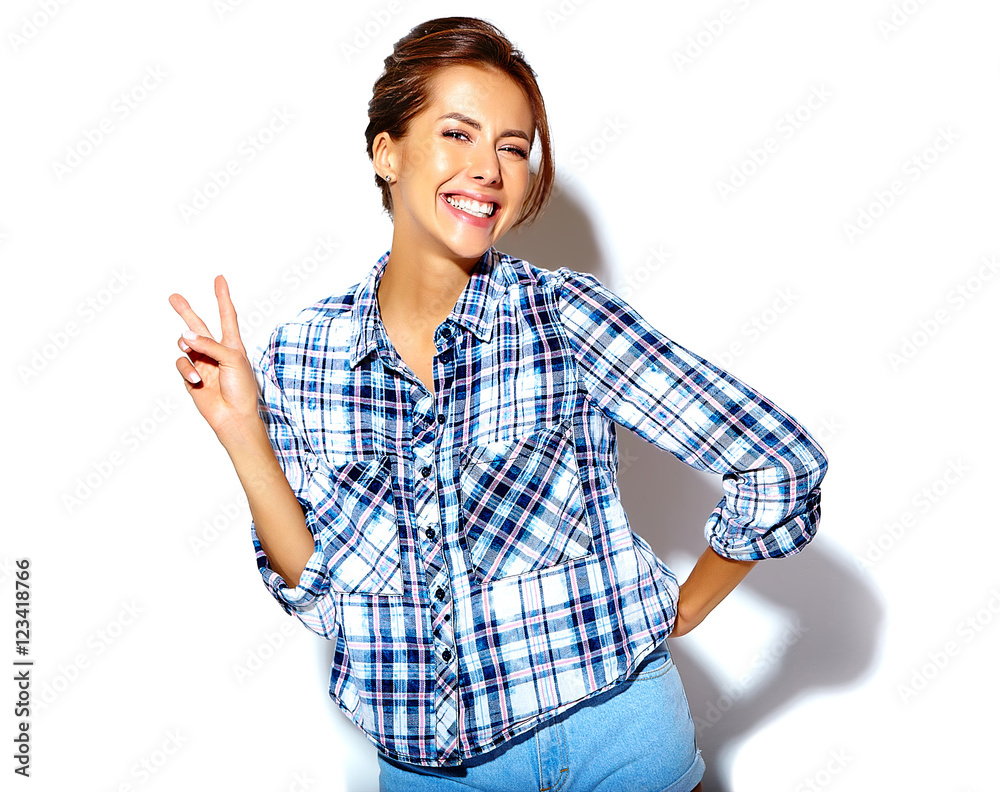 Portrait of beautiful girl model in casual summer checkered shirt with no makeup on white background showing peace sign Portrait of beautiful girl model in casual summer checkered shirt with no makeup on white background showing peace sign