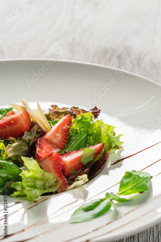 Salad greens, cheese and strawberries with balsamic sauce.