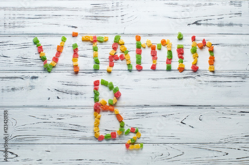 From pieces of colored candied fruits laid out the word vitamin B2. photo