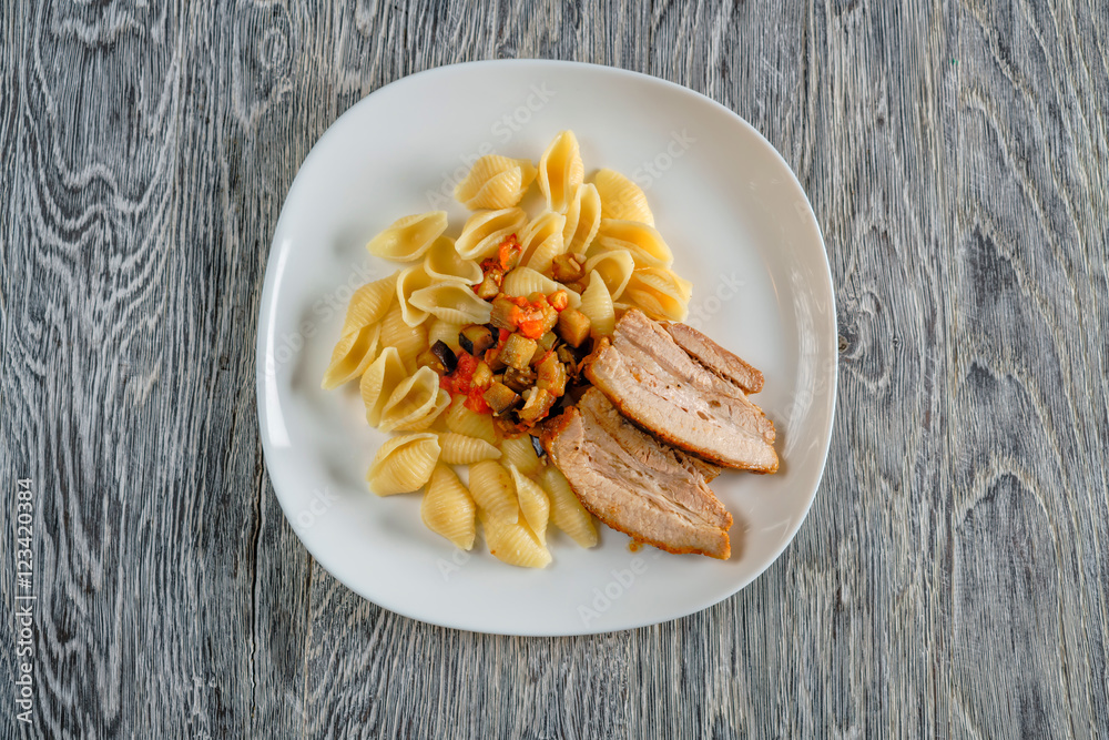 Colorful konchiglie pasta with tomatoes on wooden table. Top view with copy space