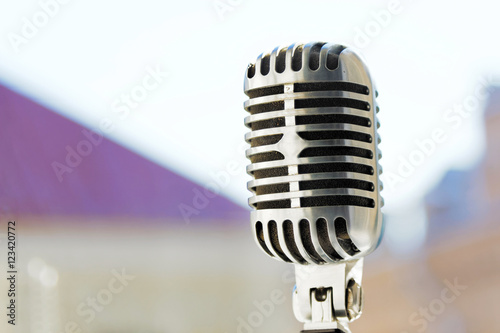 Old style vocal microphone. Retro classic design. Tinted photo.