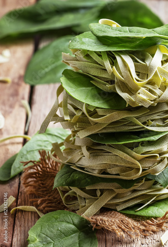 Dry spinach pasta with green leaves, folded like a tower, vintag