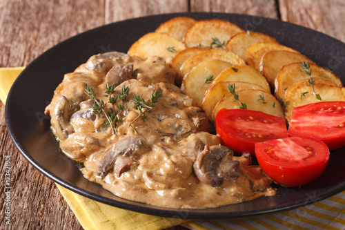 Photography Diana steak garnished with fried potatoes and fresh tomatoes close-up