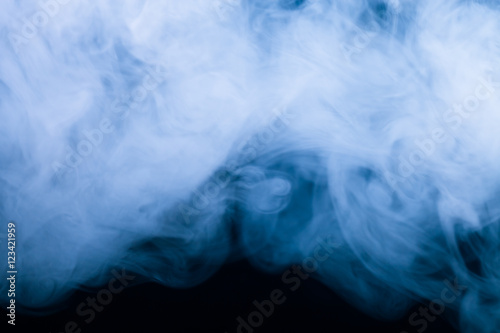 Cloud of smoke on black background. Selective focus. Toned