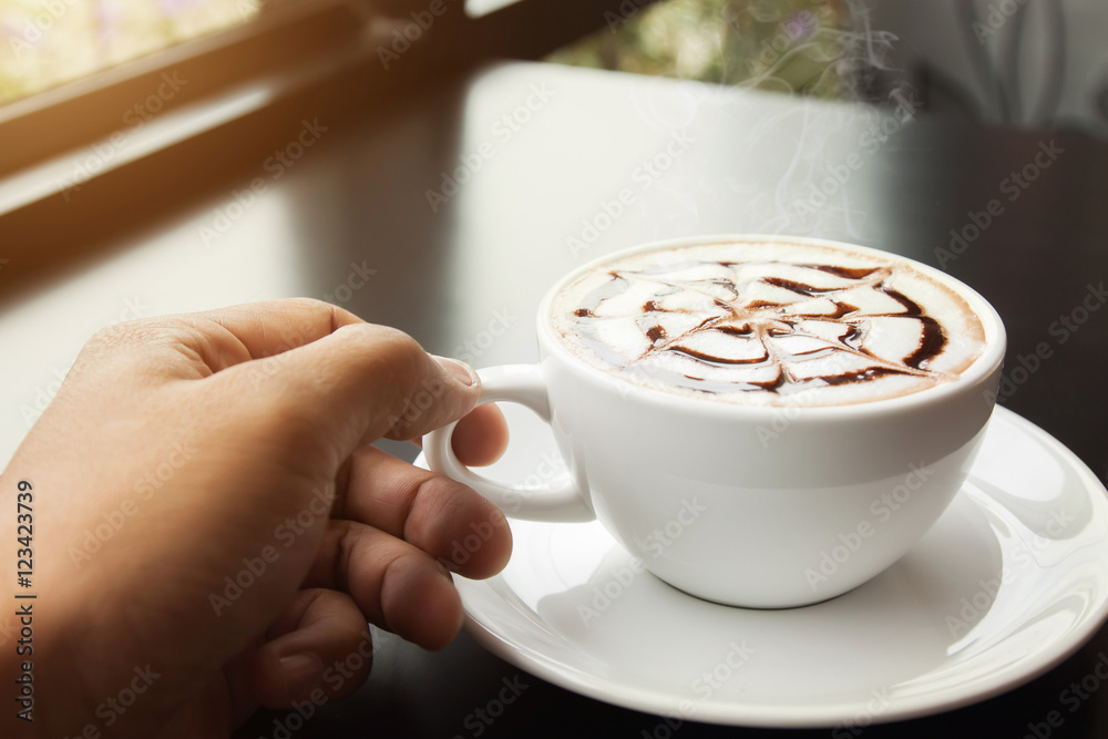 Man's hand holding a cup of coffee cafes. Man's hand holding a cup of coffee cafes.