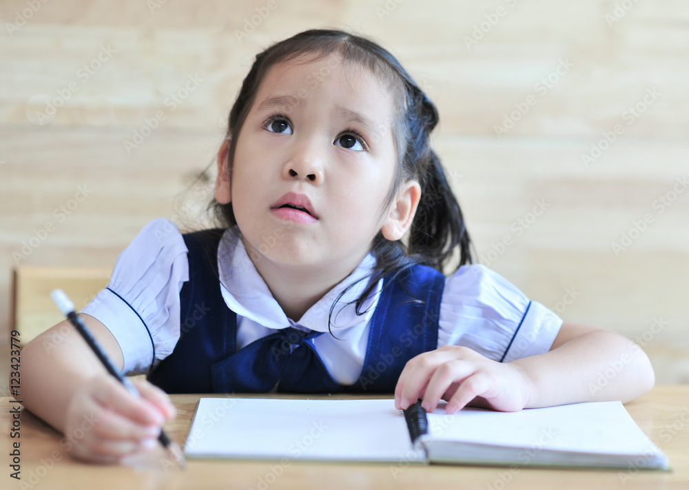 little schoolgirl littening lesson hold pencil on notebook the table school uniform little schoolgirl littening lesson hold pencil on notebook the table school uniform