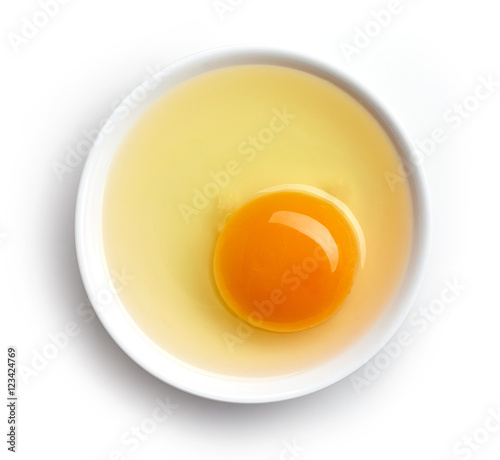 Bowl of egg yolk isolated on white, from above