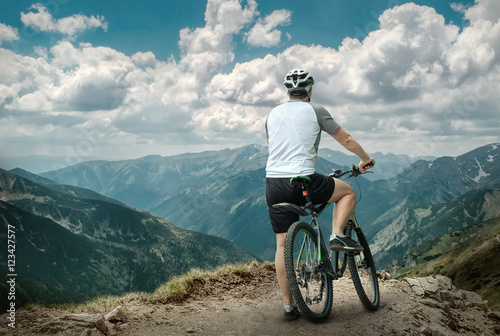 Fototapeta Naklejka Na Ścianę i Meble -  Men with bicycle aroun mountains beautiful view.