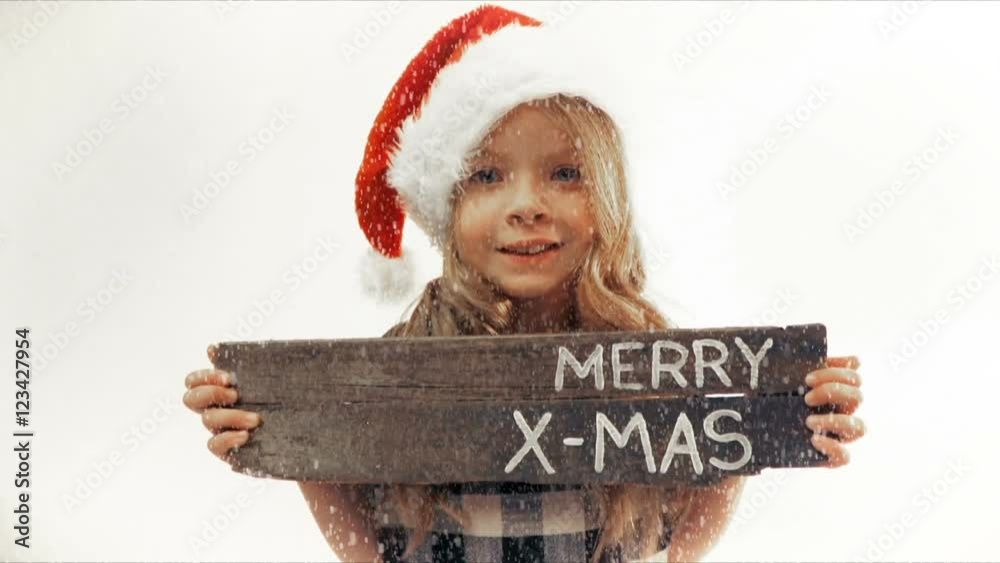 hübsches mädchen hält hölzernes schild mit merry x-mas