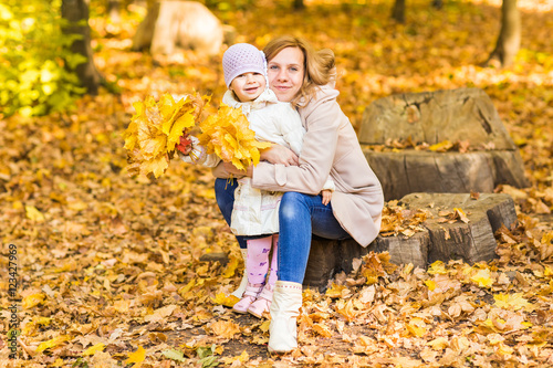 Happy woman and daughter in the autumn park