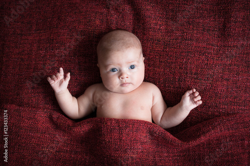 baby on a red burgundy background close-up, different emotions
