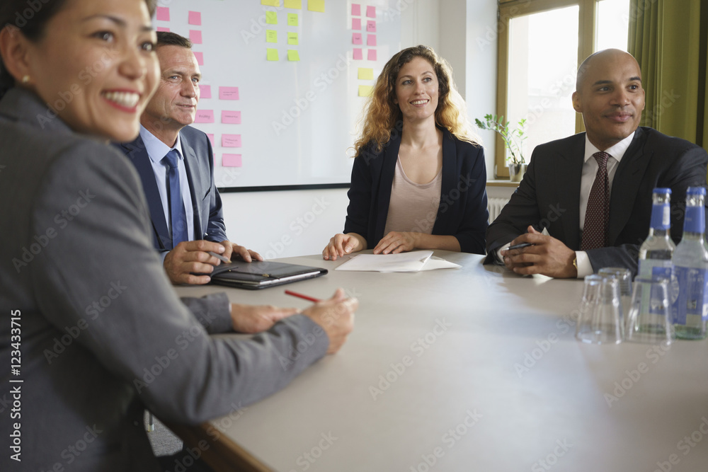 Smiling business people sitting in meeting at conference room Smiling business people sitting in meeting at conference room