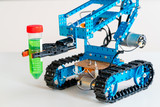 The robot arm tracks on doing an experiment with dangerous chemicals