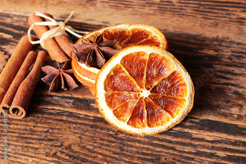 Getrocknete Orangenscheiben mit Sternanis und Zimtstangen auf altem Holztisch
 photo