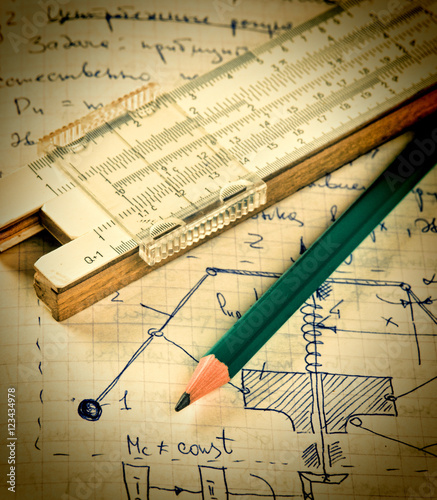 pencil and a slide rule on the old page with the calculations in photo