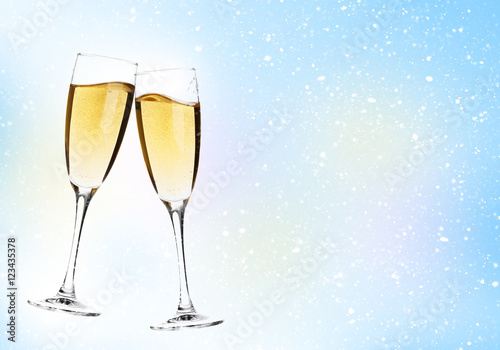 Two champagne glasses over christmas background