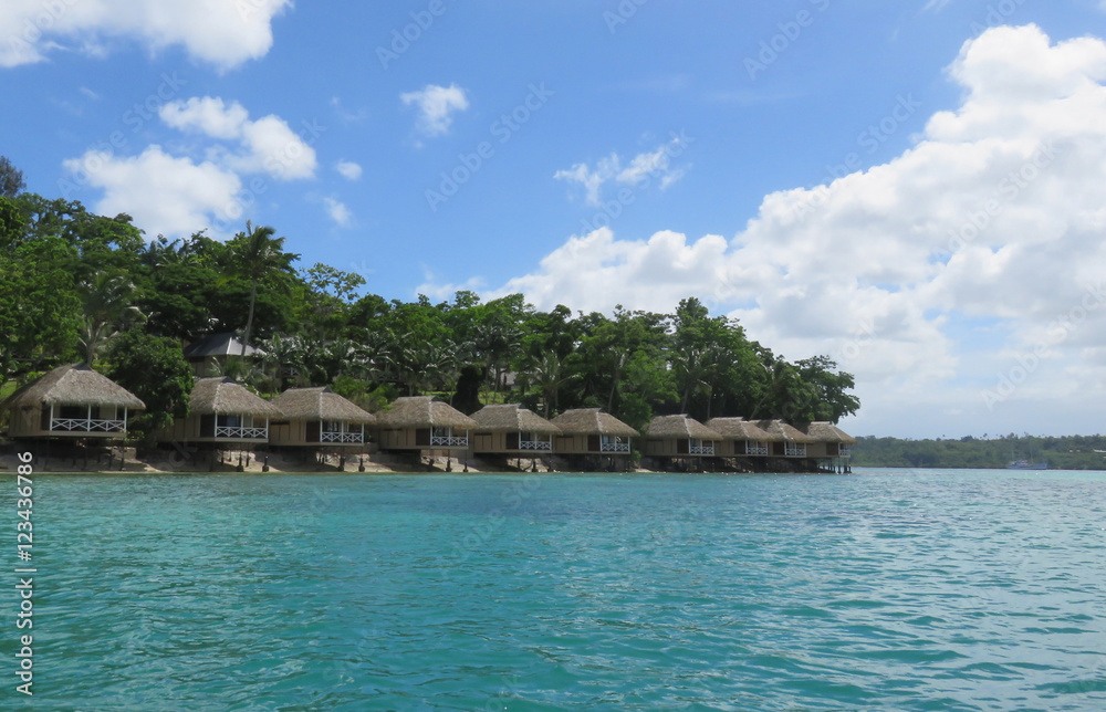A row of bungalows by the emerald water