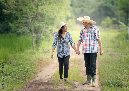 Happy senior couple taking a walk in summer countryside. © Sasint