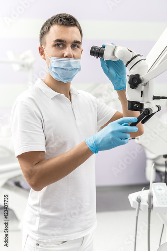 Dentist holds dental microscope © Andriy Bezuglov