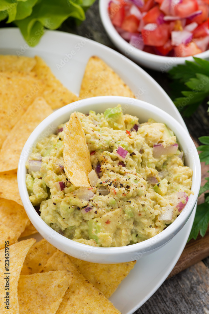 guacamole sauce and corn chips, vertical closeup guacamole sauce and corn chips, vertical closeup