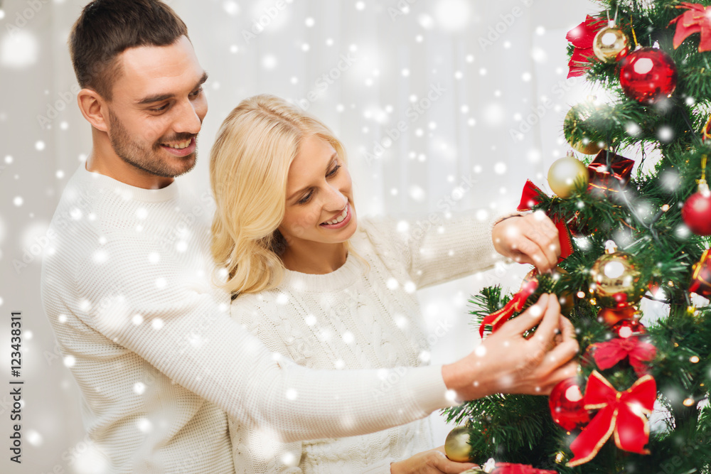 happy couple decorating christmas tree at home happy couple decorating christmas tree at home