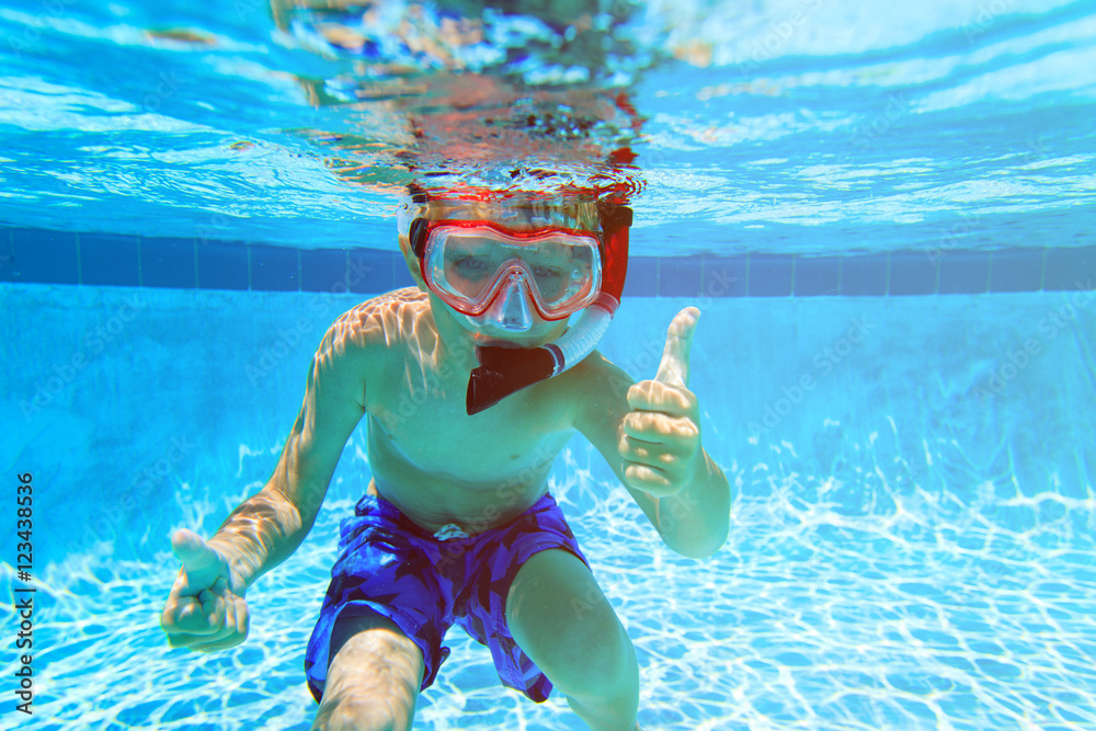 happy little boy swimming underwater with thumbs up