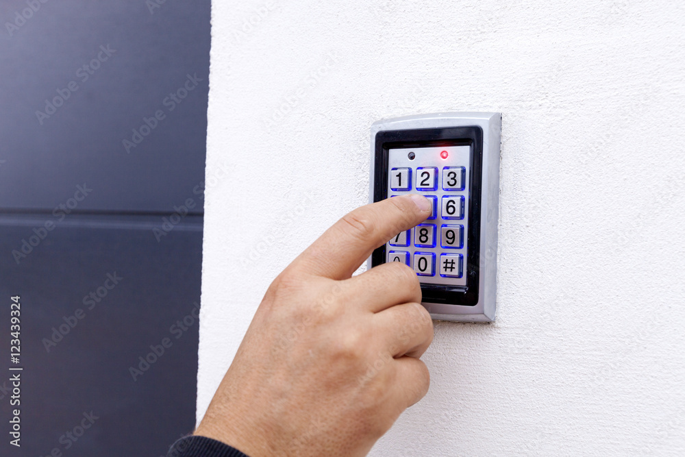 Man dialing pass code on intercom security keypad to open entrance door of the apartment building. Man dialing pass code on intercom security keypad to open entrance door of the apartment building.