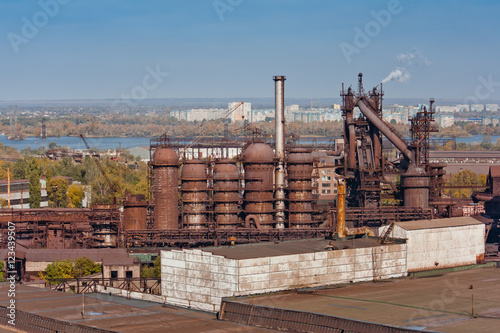 Industrial landscape with metallurgical plant. City in the background