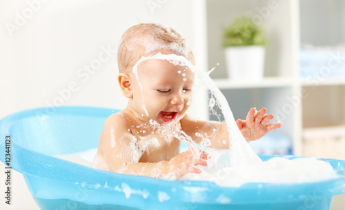 Fotografering Happy toddler bathing in bathtub