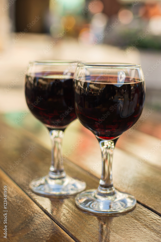 glasses with red wine on a table at an outdoor cafe with a blurr