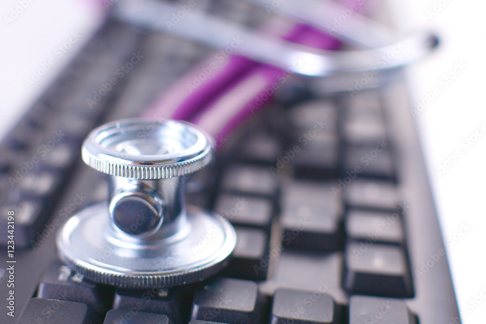 Medical stethoscope lying on a computer keyboard, documents Medical stethoscope lying on a computer keyboard, documents