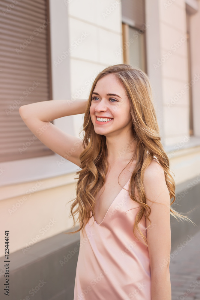 Naklejka premium fashion outdoor photo of gorgeous young woman with blond curly hair in elegant clothes posing