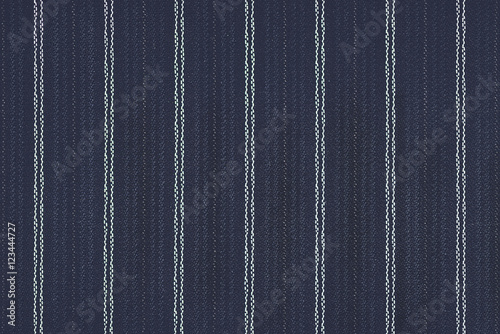 Close up of pinstriped fabric texture background.Detail of navy blue wool suiting with twin white pinstriped