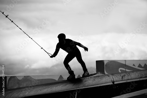 Wakeboarder making tricks in park. Extreme life concept. Copy space for advertising text.