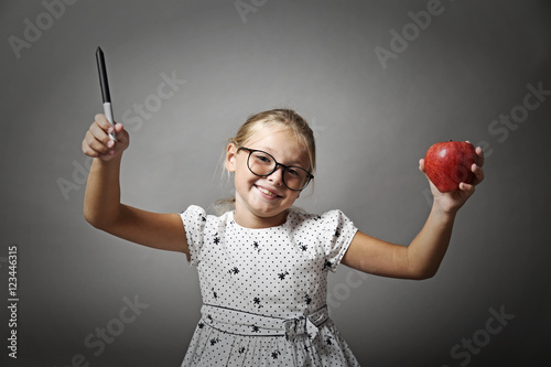 Bambina sorridente con la mela in mano photo